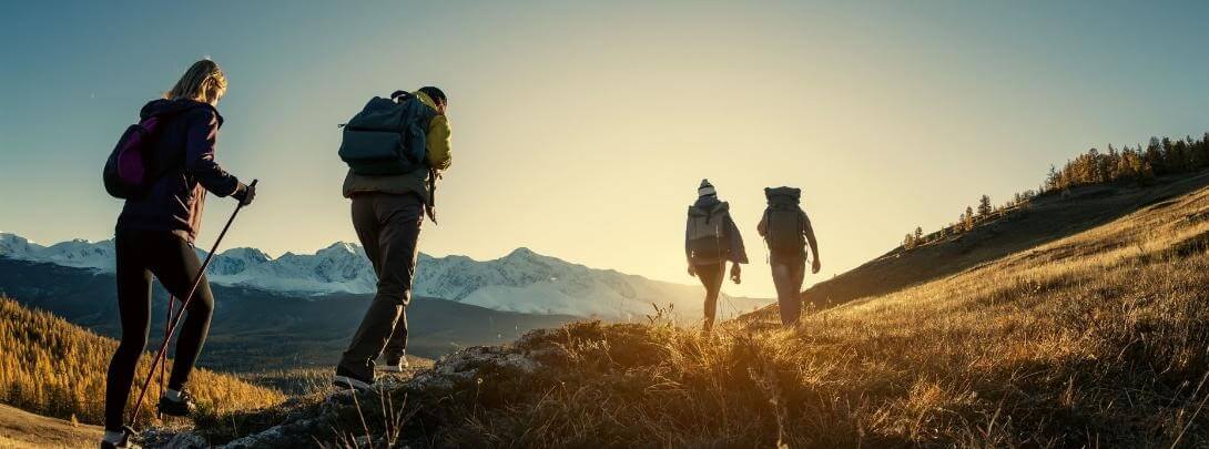 A Group of 4 People With Back Packs Are Hiking Into the Mountains